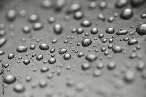 Water droplets on dark surface with dramatic monochrome texture.