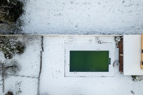 TOP DOWN DRONE VIEW OF A POOL IN WINTER SNOW