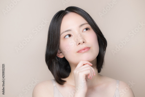 Japanese women struggling with skincare and beauty concerns; a natural close-up portrait evoking the image of beautiful skin; looking up