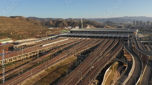 Drone shot of high-speed bullet train leaving massive modern Kunming South railway station in China