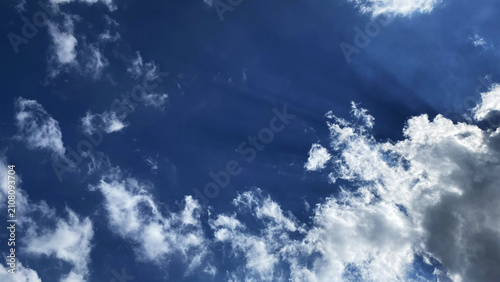 Fluffy white clouds against intense dark blue sky