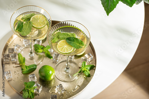 Refreshing mojito cocktails with mint and lime on tray