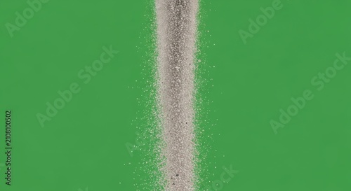 A flowing cascade of fine granular material resembling a dry earth stream descending against a vibrant green expanse conveying a sense of natural elemental motion and textural dispersion suitable for 