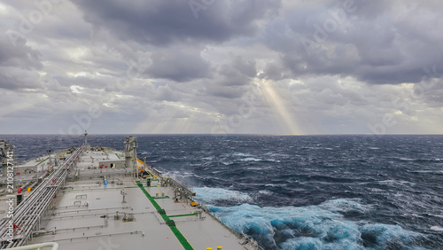 Photos Wide angle view of oil tanker ship bow cutting through rough sea waves under dra