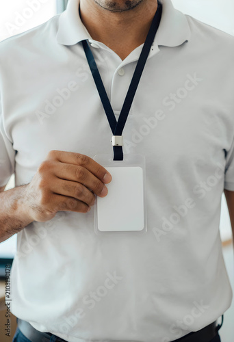 Man in white polo shirt hol...