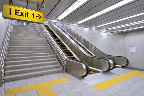Modern Escalators and Stairs Leading to Exit Sign in Subway Station.