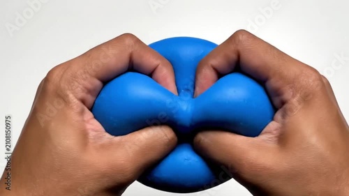 Close-up of hands squishing and stretching a blue stress relief ball