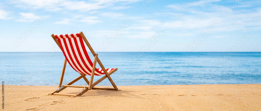 Fotografie Red striped deck chair on sandy beach