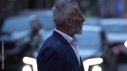 Elegant mature businessman checking his wristwatch before an important meeting, silver haired executive representing leadership, experience, confidence, success and time management