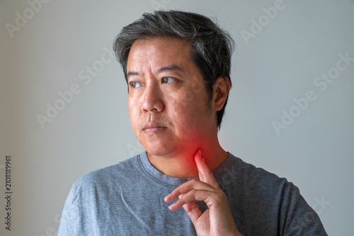 фотографія Man touching inflamed throat with red highlight, symbolizing sore throat, bronchitis, and tonsillitis infection healthcare concept