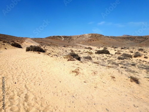 Sand dunes and arid coastal landscape at Playa Mujeres, Lanzarote, Canary Islands, Spain