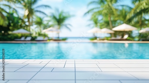 A serene poolside scene with clear blue water, tiled deck, palm trees, and white umbrellas under a bright, sunny sky.