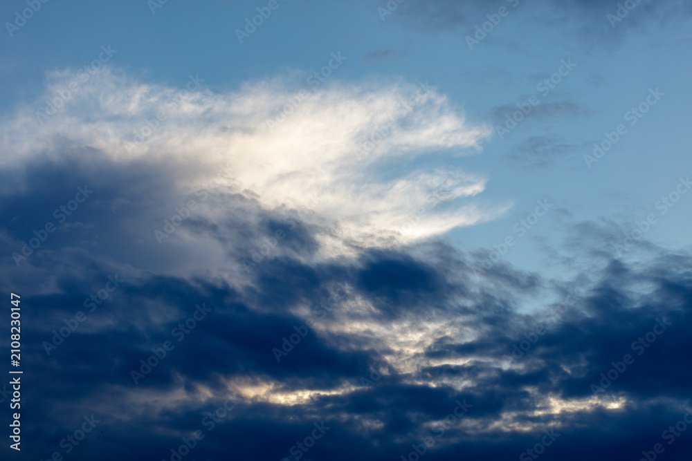 Fototapeta premium Dramatic sky with dark clouds and bright illuminated wisps