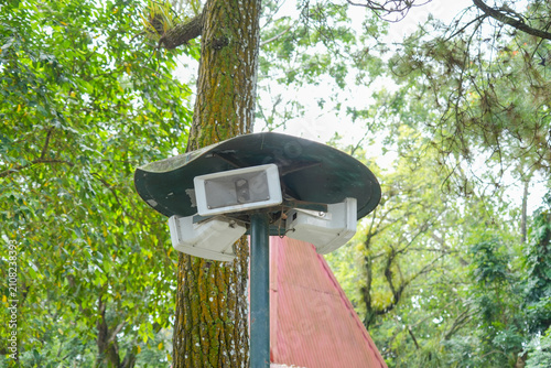 Картината върху платно An outdoor public address horn loudspeaker system mounted on a pole in a public park