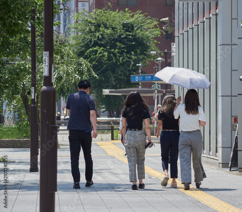 夏の昼の名古屋の繁華街で歩く若い女性たちの姿