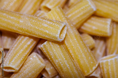 Cuadro en lienzo Raw rigatoni pasta close-up, texture of dry Italian unbaked tubular pasta backgr