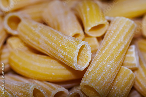 Cuadro en lienzo Raw rigatoni pasta close-up, texture of dry Italian unbaked tubular pasta backgr