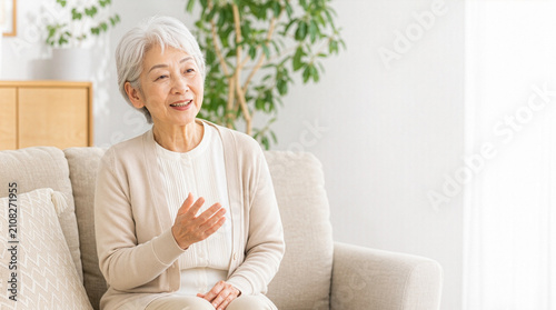 穏やかな笑顔でインタビューに答える親しみやすい日本人シニア女性
Friendly senior Japanese woman answering an interview in a bright modern living room