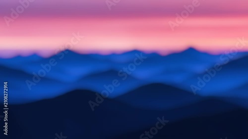 A hazy  of a mountain range during the golden hour of sunset