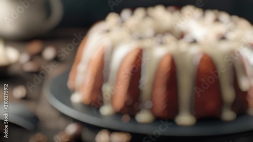 A single bundt cake sits on a black plate, ready to be served or displayed