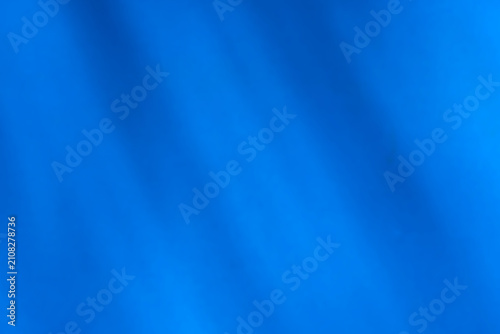 Blurred dark blue fabric background featuring soft light and shadow.