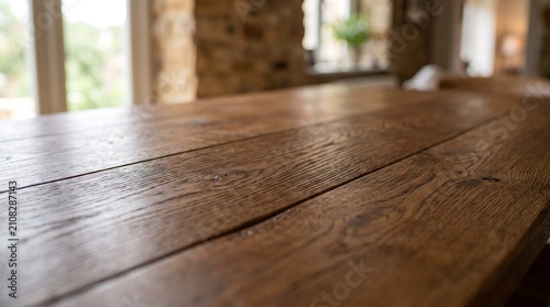 Close up of a rustic wooden table surface with a blurred background of a bright room interior