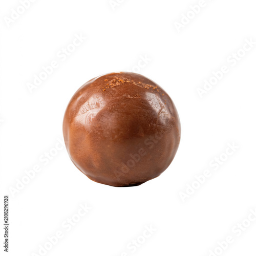 Single round chocolate truffle with smooth surface lit by studio lighting isolated on transparent background