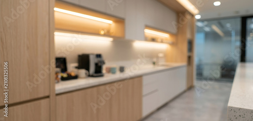 Fully blurred modern office pantry with coffee station, elegant cabinetry and warm ambient lighting creating a welcoming commercial corporate background without people