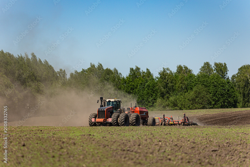 Obraz premium Modern tractor seeding farmland with precision agriculture equipment