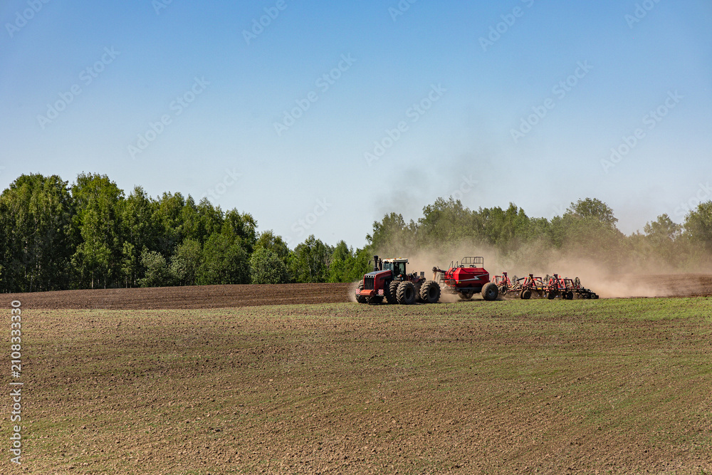 Obraz premium Modern tractor seeding agricultural field during spring planting season