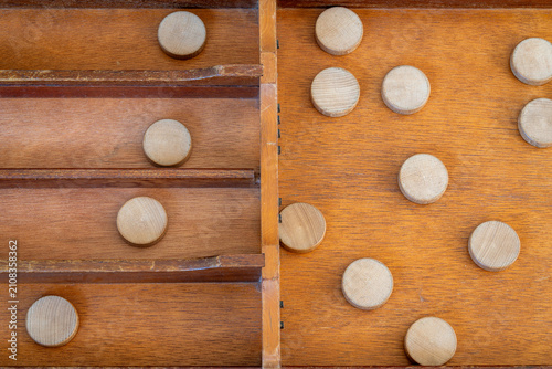 Sjoelen gameplay, classic dutch tabletop board game with wooden pucks and board called sjoelbak, top down view