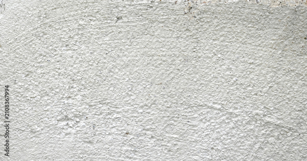 Obraz premium Horizontal close up of a concrete barrier block surface with a rough flat uneven light gray concrete texture and tough marks 