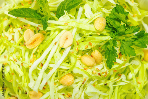 Konstfotografi Fresh shredded cabbage salad with peanuts, sesame seeds, mint, and parsley in a