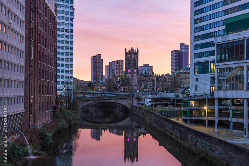 Fototapeta premium View along the River Irwell at sunrise towards Manchester Cathedral, England, Uk