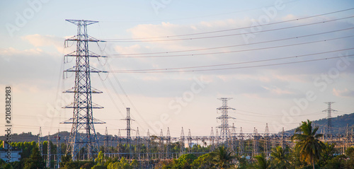 High voltage power transmission towers and electrical substation with evening sky background.Electricity pylon and high voltage power line network against colorful sunset sky.