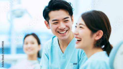 明るく笑顔で会話する日本人の歯科医師と歯科スタッフ｜歯科医院のコミュニケーション素材