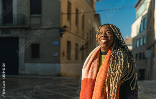 African american woman smiling outdoor enjoying sunlight in city