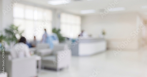 A blurred image of a modern hospital reception area, featuring seating areas, medical staff, and a welcoming atmosphere for patients and visitors.
