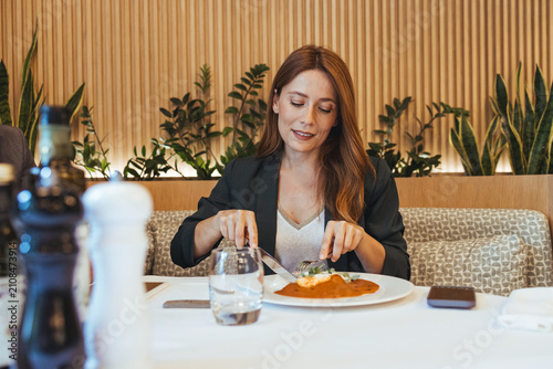 Quadro su tela Businesswoman Enjoying Gourmet Lunch in Modern Restaurant During Casual Business