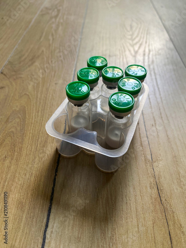 Reta, retatrutide peptide in a vial on a wooden background.	