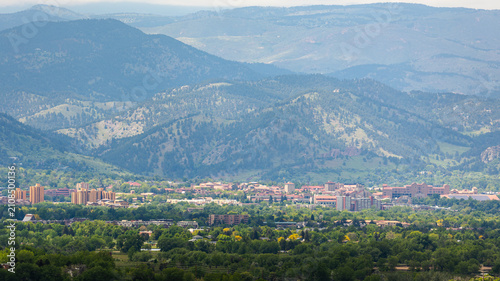 A scenic view of Boulder, Colorado, showcases the town nestled against the dramatic backdrop of the Rocky Mountains and the iconic Front Range.