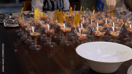 A waiter orders cups of ceviche to be served at a luxury party