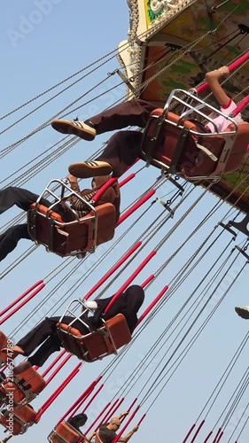 Visitors of the amusement park are enjoying the wave swinger ride. Visitors are excited to try the swing ride at the amusement park