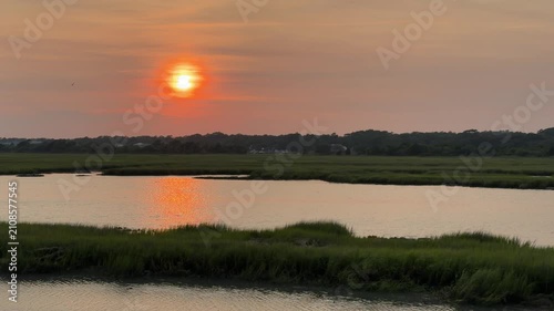 Establishing shot of a gorgeous sunset across an inlet at the beach with copy space