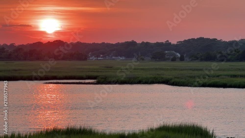 Establishing shot of a gorgeous sunset across an inlet at the beach with copy space