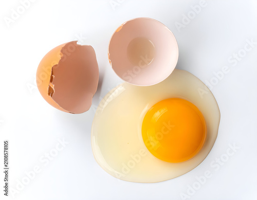 Brown egg yolk with eggshell on white background
