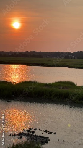 Establishing shot of a gorgeous sunset across an inlet at the beach with copy space