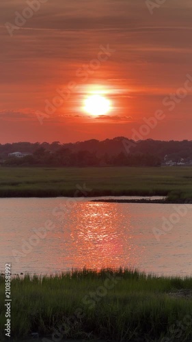 Establishing shot of a gorgeous sunset across an inlet at the beach with copy space