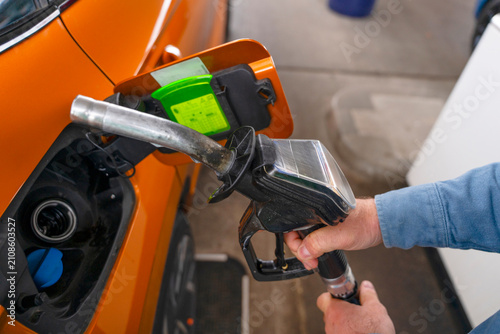 Filling up a car with fuel at a gas station during the day