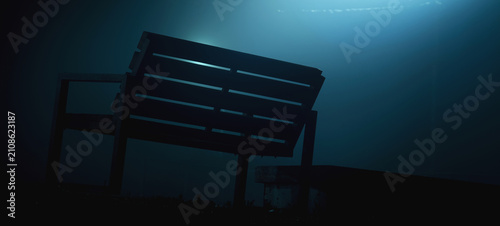 Fotografía Empty bench in dense fog at night with blue cinematic lighting